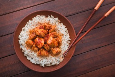 Tahta masadaki bir kasede körili tavuklu pilav. Sıcak ve baharatlı Asya yemekleri. en üstteki görünüm