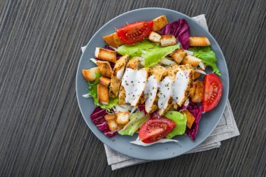Izgara tavuklu taze salata, domates, tahta masada kraker ekmeği. sağlıklı renkli yiyecekler. en üstteki görünüm