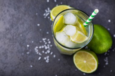 Taze yaz alkollü caipirinha 'sı taş bir masada. Parti içeceği kokteyl arka planı. en üstteki görünüm