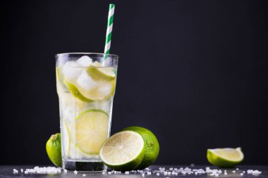 Taze yaz alkollü caipirinha 'sı taş bir masada. parti içeceği kokteyl arka planı