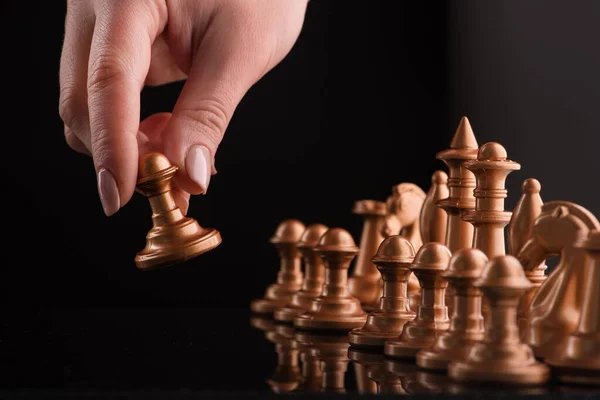 Začátek Hry Zlatými Šachy Ruka Drží Tvar Černé Pozadí Odrazy — Stock fotografie