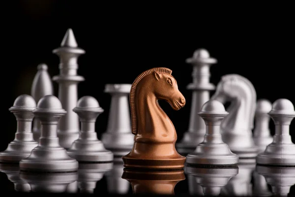 金色国际象棋骑士马相对于一般人像的背景 黑色背景 — 图库照片