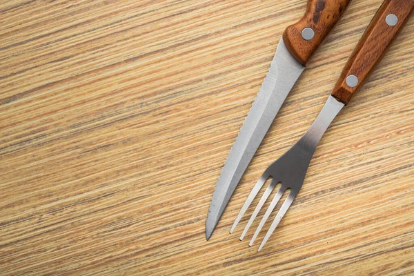 木桌上的金属叉和刀 饭后餐具的摆放 — 图库照片