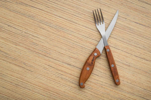 木製のテーブルの上に金属フォークとナイフ 食事後の刃物の配置 — ストック写真
