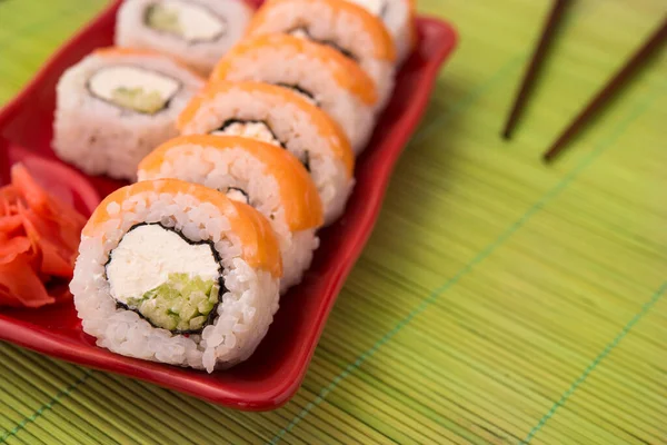 Rollo Sushi Con Salmón Mesa Roja Filadelfia Mesa Bambú Madera — Foto de Stock