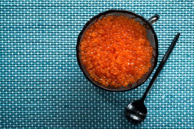 Masadaki bir kasede kırmızı havyar. Deniz ürünleri arka planı