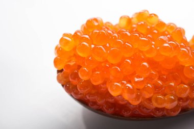 Beyaz arka planda izole edilmiş bir kaşıkta kırmızı havyar. gurme deniz ürünleri