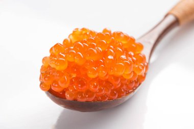 Beyaz arka planda izole edilmiş bir kaşıkta kırmızı havyar. gurme deniz ürünleri
