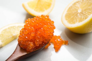 Arka planda kırmızı havyar olan bir kaşık. Aperatif deniz ürünleri