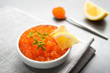 Masadaki beyaz kasede dilimlenmiş limonlu kırmızı havyar. Lüks deniz ürünleri