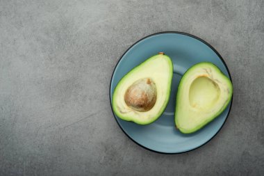 Taş bir masada çiğ yeşil avokado. Diyet yemeği. Üst görünüm