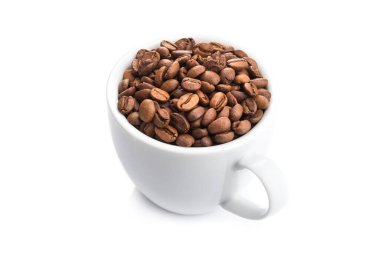 Beyaz arka planda izole edilmiş kavrulmuş kahve çekirdekleri ile dolu seramik bardak.