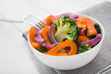 Beyaz ahşap bir masada brokoli, biber ve soğanlı düşük kalorili taze salata. Diyet organik gıda.