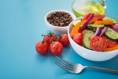 Taze sebze salatası, domates, biber, mavi arka planda salatalık. Sağlıklı beslenme.