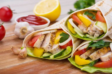 Tortilla ızgara tavuk ve taze sebzelerle ahşap bir masaya sarılır. Meksika fast food geçmişi.