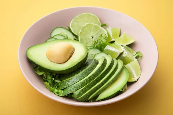 Fresh Salad Avocado Green Lime Cucumber Pastel Yellow Background Diet — Stock Photo, Image