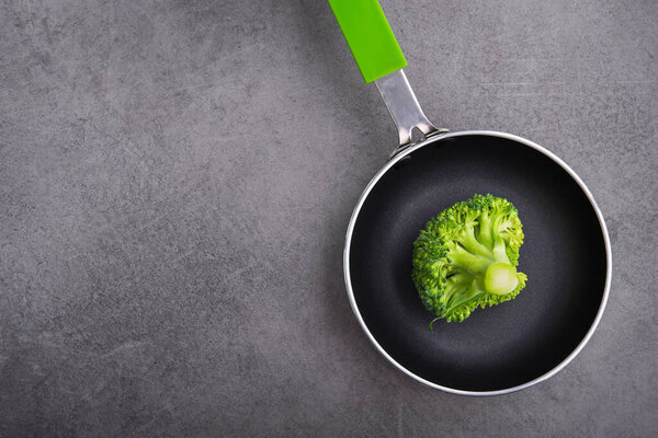 Fresh raw green broccoli in a frying pan. Diet concept background. Top view