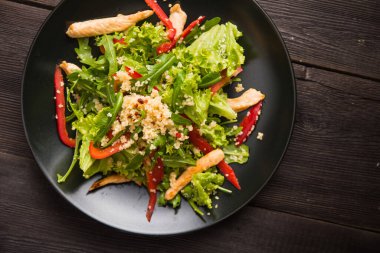 Kuskus, biber, roka ve tavuklu taze salata. en üstteki görünüm