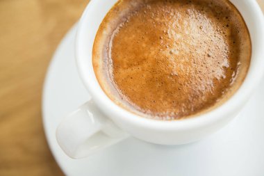 Pencere kenarındaki kafede sütlü kahve fincanı.