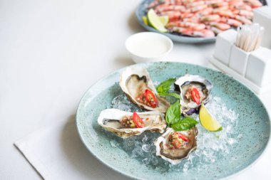 İki kişilik deniz ürünleri, restoranda akşam yemeği, masada istiridye ve karides tabağı..