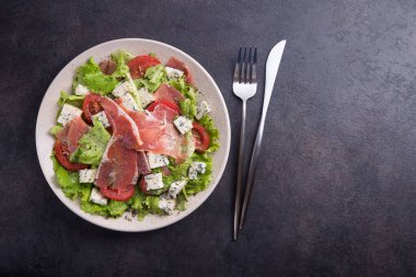Prosciutto, domates, marul ve peynirli taze salata. Üst görünüm