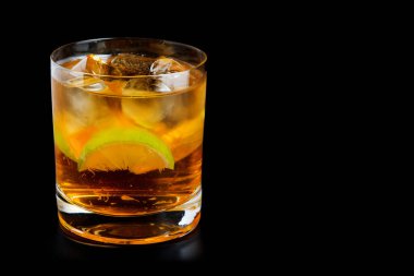 Limonlu ve buzlu soğuk alkol. Siyah arka planda Küba libre kokteyli.