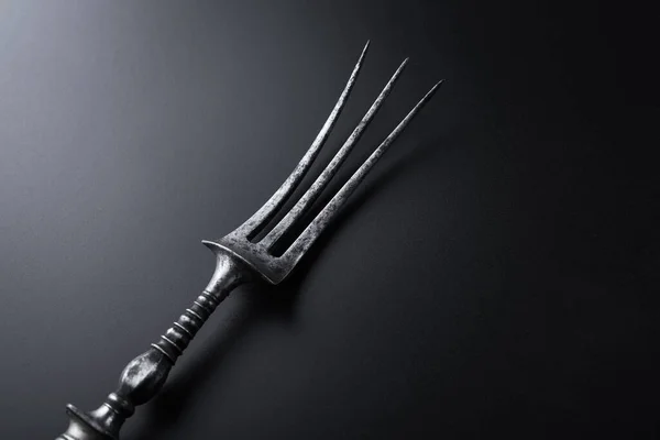 黒を背景に肉ステーキ用のメタルヴィンテージフォーク — ストック写真