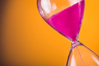 Sarı arka planda kum saati ile parlak renkli zaman.