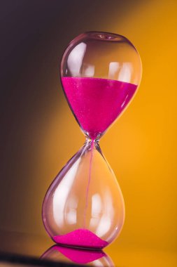 Sarı arka planda kum saati ile parlak renkli zaman.