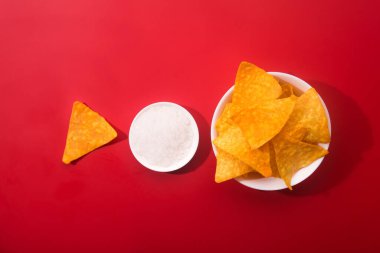 Kırmızı arka planda tuzlu nachos cipsi, düzlük, Meksika yemeği.