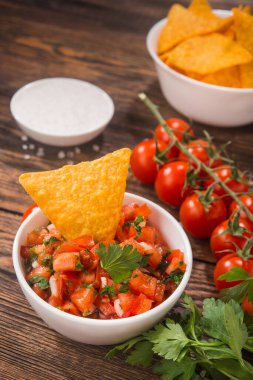 Tahta masada tortilla cipsi ve Meksika domates sosu.