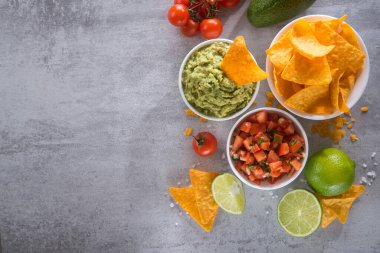 Salsa soslu ve guacamole soslu lezzetli altın çıtır cipsler. - Meksika yemeği. Düz katman.Üst görünüm
