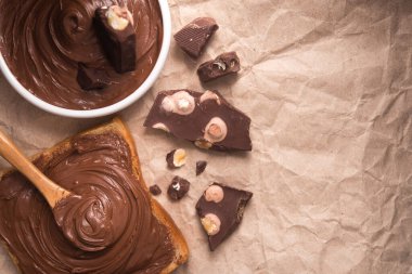 Kremalı ve çikolatalı ekmeğe sürülmüş tatlı çikolata. Üst görünüm.
