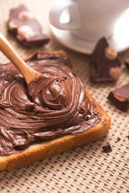 Çikolatalı ekmeğin tatlı kahvaltısı ve sabah masasında bir fincan kahve.