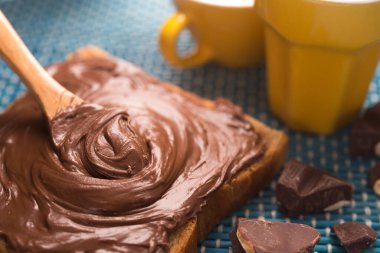 Çikolatalı ekmeğin tatlı kahvaltısı ve sabah masasında bir fincan kahve.