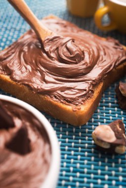 Çikolatalı ekmeğin tatlı kahvaltısı ve sabah masasında bir fincan kahve.