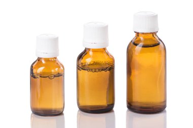 Beyaz arka planda üç şişe sıvı ilaç izole edilmiş.