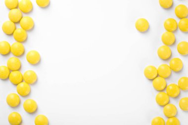 Beyaz arka planda izole edilmiş sarı haplar. en üstteki görünüm