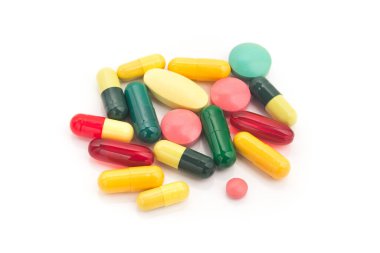 Beyaz arka planda izole edilmiş renkli ilaç ve tabletler yığını