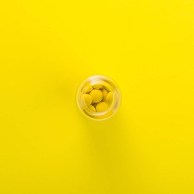 Arka planda sarı haplar kavramı, parlak minimalizm.