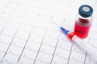 EKG sonuçları kağıt üzerinde ve kalp atışlarını düzeltmek için kırmızı enjeksiyon. Kalp krizi ya da yüksek tansiyon.