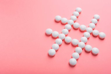 Pembe pastel arka planda beyaz haplardan yapılan etiket sembolü. yaratıcı sosyal ağlar etiketi