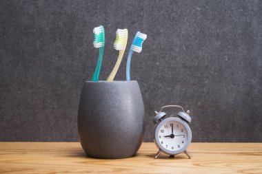 Diş fırçasını saatin yanında tut. İskandinav banyosunda diş temizliği ve bakımı kavramı.