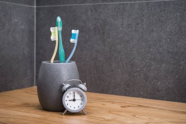 Diş fırçasını saatin yanında tut. İskandinav banyosunda diş temizliği ve bakımı kavramı. Ağız temizliği. Diş bakımı kavramı.