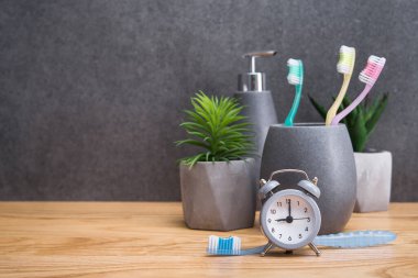 Diş fırçasını saatin yanında tut. İskandinav banyosunda diş temizliği ve bakımı kavramı.
