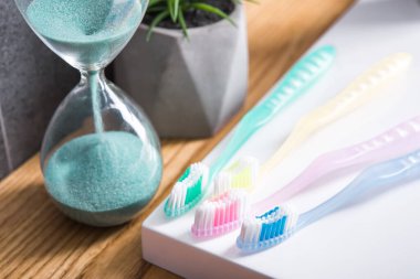 Tuvalet masasında kum saati olan diş fırçaları. Diş bakımı ve hijyen.