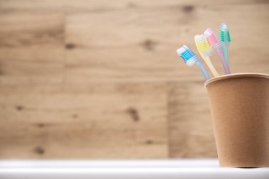 Banyodaki kağıt bardakta dört diş fırçası. Hijyen ve diş temizliği. mesaj için yer. Boşluğu kopyala