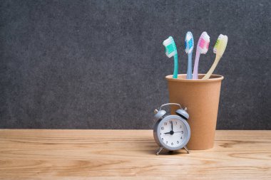 Diş fırçasını saatin yanında tut. İskandinav banyosunda diş temizliği ve bakımı kavramı.