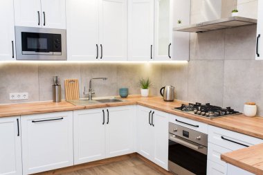 Ahşap masa üstünde dekor aksesuarları olan şık beyaz İskandinav mutfağı. modern ev tasarımı.