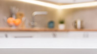 Beyaz ahşap bir masaya ve arka plana odaklanmadan İskandinav mutfağına odaklan..